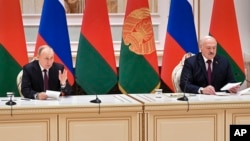 Russian President Vladimir Putin, left, and Belarusian President Alexander Lukashenko attend a briefing following their talks in Minsk, Belarus, Monday, Dec. 19, 2022. (Pavel Bednyakov, Sputnik, Kremlin Pool Photo via AP)