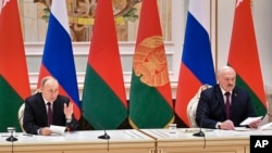 Russian President Vladimir Putin, left, and Belarusian President Alexander Lukashenko attend a briefing following their talks in Minsk, Belarus, Monday, Dec. 19, 2022. (Pavel Bednyakov, Sputnik, Kremlin Pool Photo via AP)