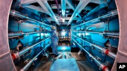 FILE - A technician reviews an optic inside a structure at the Lawrence Livermore National Laboratory in Livermore, Calif. U.S. scientists announced “major scientific breakthrough” on nuclear fusion on Dec. 13, 2022. (Damien Jemison/Lawrence Livermore National Laboratory via AP)
