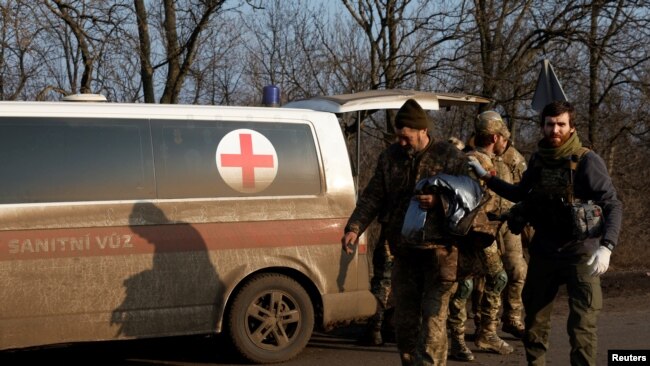 Mjekët ukrainas sjellin një ushtarak të plagosur në spitalin fushor (25 dhjetor 2022)