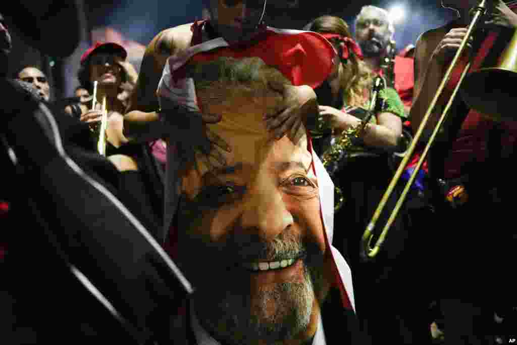 BRASIL - Un partidario brasileño del presidente electo Luiz Inácio Lula da Silva sostiene una bandera con el rostro del mandatario electo estampado después de que se confirmara su victoria en la segunda vuelta de las elecciones presidenciales, el 30 de octubre de 2022, en Sao Paulo, Brasil. La elección fue considerada como la más reñida en la época democrática del país. Lula asumirá un tercer mandato -no consecutivo- el 1 de enero de 2023.