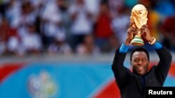 Légende brésilienne du football et membre des équipes de football brésiliennes vainqueurs de la Coupe du monde de 1958, 1962 et 1970, Pelé détient le trophée de la Coupe du monde lors de la cérémonie d'ouverture de la Coupe du monde 2006 à Munich, en Allemagne, le 9 juin 2006.