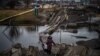 A woman crosses a destroyed bridge in Bakhmut, Donetsk region, Jan. 6, 2023.