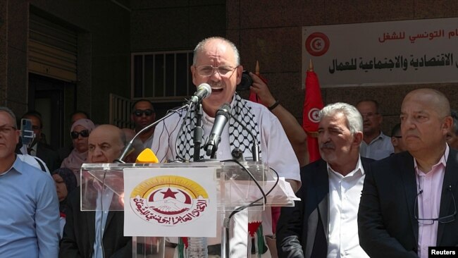 FILE - Noureddine Taboubi, secretary general of the Tunisian General Labour Union (UGTT) speaks to supporters of the union during a national public strike called by them, outside their headquarters in Tunis, June 16, 2022.