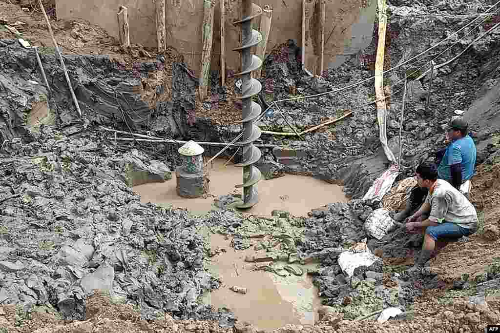 Rescuers gather at the site of where a 10-year-old boy is thought to be trapped in a 35-meter deep shaft at a bridge construction area in Vietnam&#39;s Dong Thap province.