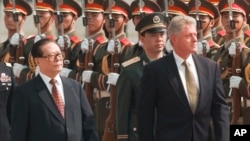 FILE - Then U.S. President Bill Clinton, right, and the then Chinese President Jiang Zemin, left, review Chinese troops during arrival ceremonies at east the plaza of the Great Hall of the People in Beijing, June 27, 1998.