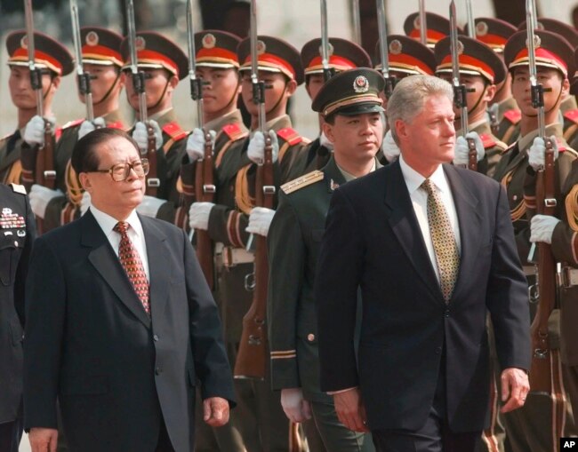 FILE - Then U.S. President Bill Clinton, right, and the then Chinese President Jiang Zemin, left, review Chinese troops during arrival ceremonies at east the plaza of the Great Hall of the People in Beijing, June 27, 1998. (AP Photo/David Longstreath, File)