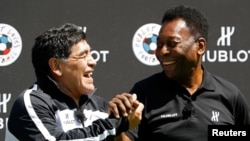 Football legends Pele, right, and Diego Maradona attend a promotional event on the eve of the opening of the UEFA 2016 European Championship in Paris, June 9, 2016.