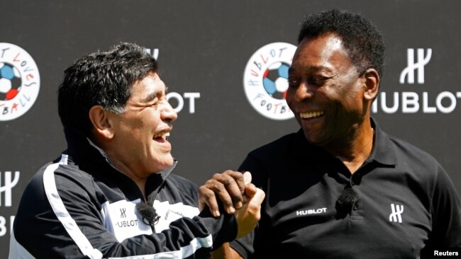 Football legends Pele, right, and Diego Maradona attend a promotional event on the eve of the opening of the UEFA 2016 European Championship in Paris, June 9, 2016.