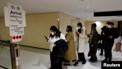 2023年1月8日，从北京抵达日本东京成田机场的乘客正前往防疫检测中心。（路透社）