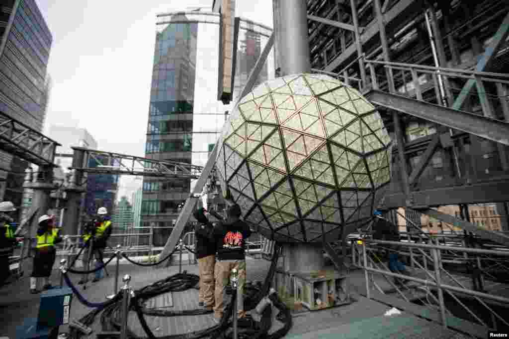 Workers install sparkling new Waterford Crystal triangles on the Times Square New Year&#39;s Eve Ball on the roof of One Times Square in Manhattan, New York.