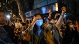 2022年11月27日，人们聚集在上海的一条街道上抗议中国的零 Covid 政策。