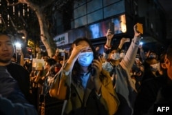 People gather on a street in Shanghai on Nov. 27, 2022, where protests against China's zero-COVID policy took place the night before following a deadly fire in Urumqi, the capital of the Xinjiang region.