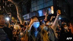 People gather on a street in Shanghai on Nov. 27, 2022, where protests against China's zero-COVID policy took place the night before following a deadly fire in Urumqi, the capital of the Xinjiang region. 