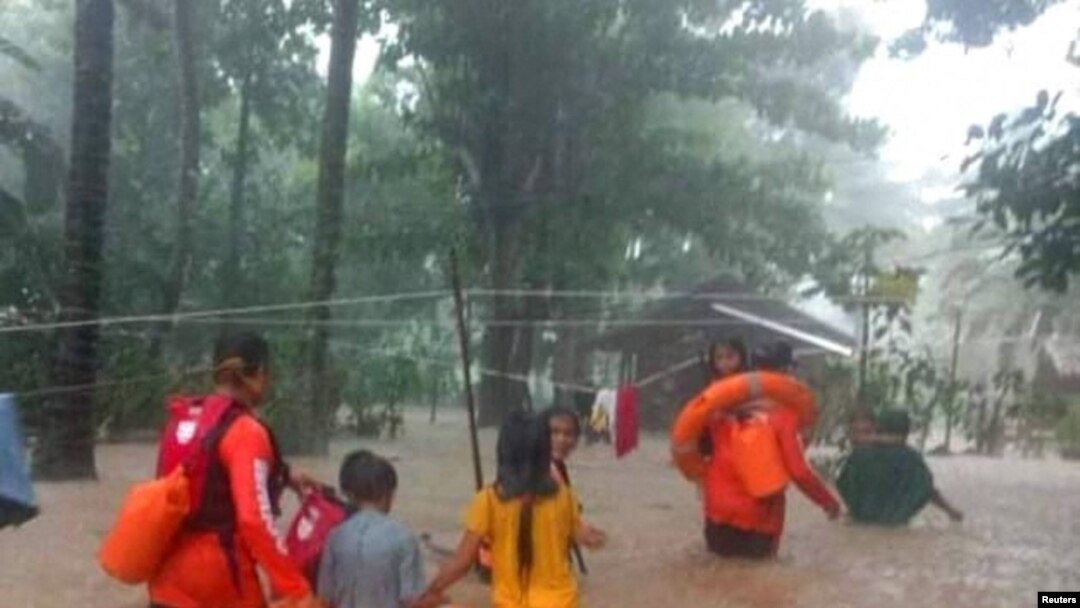 Rescue workers help people affected by floods, in Plaridel, Misamis Occidental Province, Philippines, Dec. 26, 2022.(Philippine Coast Guard)
