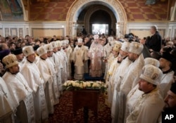 Metropolitan Epiphanius, center right, and priests deliver an Orthodox Christmas service inside the nearly 1,000-year-old Pechersk Lavra Cathedral of Kyiv, Ukraine, Jan. 7, 2023.