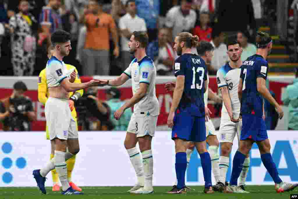 Basani ba Etats-Unis na baye ba Angleterre bapesani mbote na suka ya match ya groupe B ya Mondial Qatar 2022 na stade Al Khor, Doha, 25 novembre 2022. (Photo Kirill KUDRYAVTSEV / AFP)