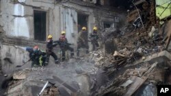 Ukrainian State Emergency Service firefighters clear the rubble at a building that was destroyed by a Russian attack in Kryvyi Rih, Ukraine, Dec. 16, 2022.