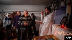 A priest leads an Orthodox Christmas Mass in a basement shelter in Chasiv Yar, Eastern Ukraine, on Jan. 7, 2023, amid the Russian invasion of Ukraine.
