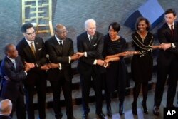 President Joe Biden holds hands with Sen. Raphael Warnock, and Keisha Lance Bottoms, senior adviser to President Biden for public engagement, after Biden spoke at Ebenezer Baptist Church in Atlanta, Jan. 15, 2023.