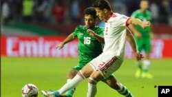 Voria Ghafouri, kanan, yang saat itu menjadi pemain timnas Iran, bertarung memperebutkan bola dalam pertandingan sepak bola Piala Asia AFC di Stadion Al Maktoum di Dubai, Uni Emirat Arab, 16 Januari 2019. (Foto: AP)