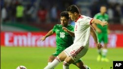 FILE— Voria Ghafouri, right, then an Iranian national soccer team player, fights for the ball during the AFC Asian Cup soccer match at the Al Maktoum Stadium in Dubai, United Arab Emirates, Jan. 16, 2019. 