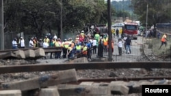 People gather near a burnt out truck at the entrance of the damaged bridge where a gas tanker exploded in Boksburg near Johannesburg, South Africa, Dec. 24, 2022. 