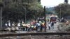 Des gens se rassemblent près d'un camion incendié à l'entrée du pont endommagé où un pétrolier a explosé à Boksburg près de Johannesburg, Afrique du Sud, le 24 décembre 2022.