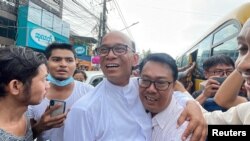Mya Aye, center-left, a prominent political activist who was imprisoned in February of 2021, is greeted as he walks free after his release from Insein prison in Yangon, Myanmar Nov. 17, 2022. (Assistance Association for for Myanmar Based Independent Journalists via Reuters.)
