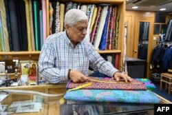 Manu Melwani dari Sam's Tailor bekerja di tokonya di Hong Kong, 25 Oktober 2022.