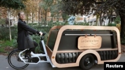 Direktur rumah duka Isabelle Plumereau berpose di atas sepeda jenazahnya, sebuah alternatif dari kendaraan bermotor tradisional, di Paris, Prancis, 2 November 2022. REUTERS/Yiming Woo