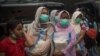 Para ibu membawa bantuan sembako di posko pengungsi di Cianjur, Jawa Barat, 24 November 2022. (Foto: Antara/Wahyu Putro A via REUTERS)