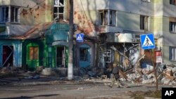 বাখমুতে যুদ্ধ বিধ্বস্ত এলাকা দিয়ে একজন বাসিন্দা হেঁটে যাচ্ছেন। ২০ ডিসেম্বর ২০২২।