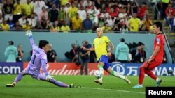 Richarlison de Brasil en acción contra el guardameta Kim Seung-gyu de Corea del Sur, en un partido que concluyó 4-1 para los cariocas y les dio el pase a cuartos de final, en Doha, Qatar, el 5 de diciembre de 2022.