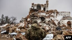 Caesar, 50-year-old, a Russian who joined the Freedom of Russia Legion to fight on the side of Ukraine, stands in front of a destroyed monastery in Dolyna, eastern Ukraine on Dec. 26, 2022.