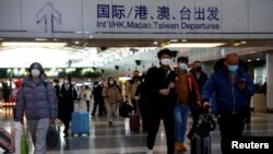 Travelers walk with their luggage at Beijing Capital International Airport, amid the COVID-19 outbreak in Beijing, Dec. 27, 2022. 