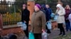 FILE - People stand in line to fill containers with water from public water pumps in Kyiv, Ukraine, Oct. 31, 2022.