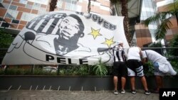 Fans install a flag with the image of Brazilian soccer legend Pele during a vigil outside the Albert Einstein Israelite Hospital entrance, where he is hospitalized, in Sao Paulo, Brazil, Dec. 4, 2022.