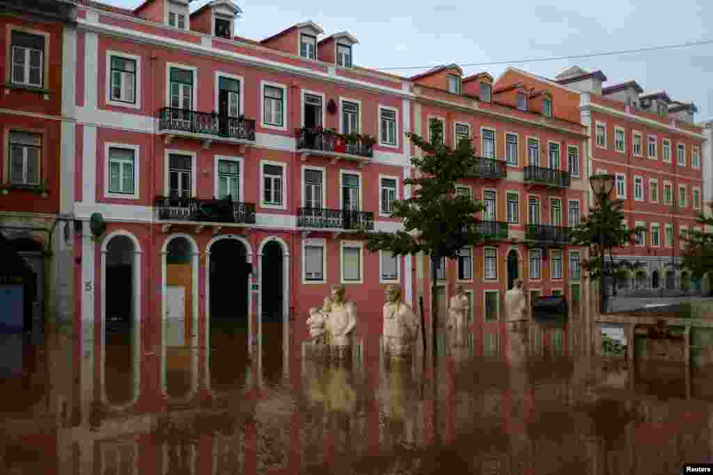 Underwater statues are seen in a flooded street in Alges, Oeiras, Portugal.