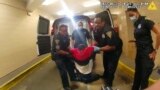 FILE - In this image taken from police body camera video provided by New Haven Police, Richard "Randy" Cox, center, is pulled from the back of a police van and placed in a wheelchair after being detained by New Haven Police on June 19, 2022, in New Haven, Connecticut. 
