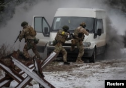 Ukrainian servicemen participate in joint drills by the armed forces, national guard and Security Service of Ukraine (SBU), near the border with Belarus, in Ukraine, Jan. 11, 2023.