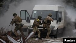 Militares ucranianos asisten a ejercicios conjuntos de las fuerzas armadas, la guardia nacional y el Servicio de Seguridad de Ucrania cerca de la frontera con Bielorrusia, en Ucrania, el 11 de enero de 2023.
