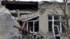 A woman measures size of a broken hospital window following recent shelling in the course of Russia-Ukraine conflict in Donetsk, Russian-controlled Ukraine, Dec. 15, 2022.