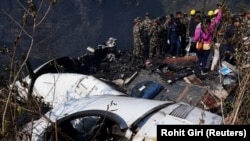 Tim penyelamat bekerja untuk mengevakuasi jenazah dari reruntuhan di lokasi jatuhnya pesawat yang membawa 72 orang di Pokhara, Nepal barat, 15 Januari 2023. (Foto: REUTERS/Rohit Giri)