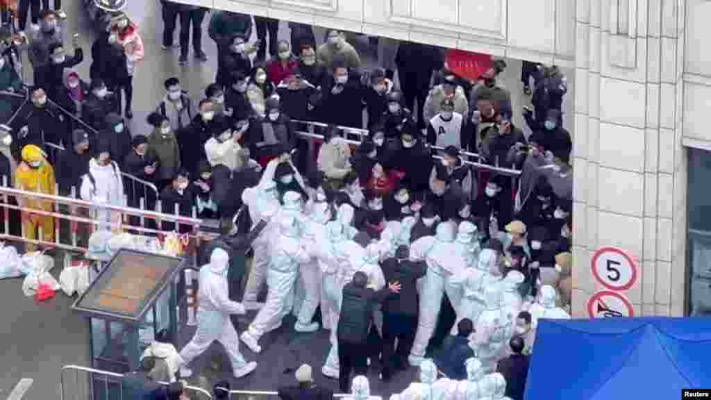 Shanghai locals confront COVID-19 workers dressed in protective clothing in Shanghai, China, in this still image obtained from a social media video released.