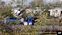Sejumlah warga tampak berdoa di dekat sebuah rumah bergerak yang hancur diterjang tornado di Flatwood, Alabama, pada 30 November 2022. (Foto: AP/Butch Dill)