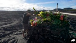 Allen Mozo leaves an offering at an alter below the Mauna Loa volcano as it erupts, Dec. 1, 2022, near Hilo, Hawaii.