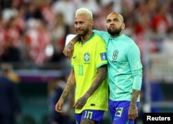 Neymar dan Dani Alves terlihat sedih setelah Brazil kalah dalam adu penalt melawan Kroasia. (Foto: REUTERS/Hannah Mckay)