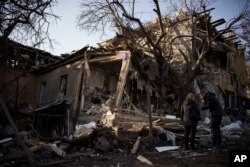 Serhii Kaharlytskyi, right, stands outside his home, destroyed after a Russian attack in Kyiv, Jan. 2, 2023. Kaharlytskyi's wife Iryna died in the attack on Dec. 31, 2022.