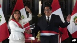 Peru's President Dina Boluarte and her newly named Economy Minister Alex Contreras wave during a swearing-in ceremony for her cabinet members, at the government palace in Lima, Peru, Dec. 10, 2022.
